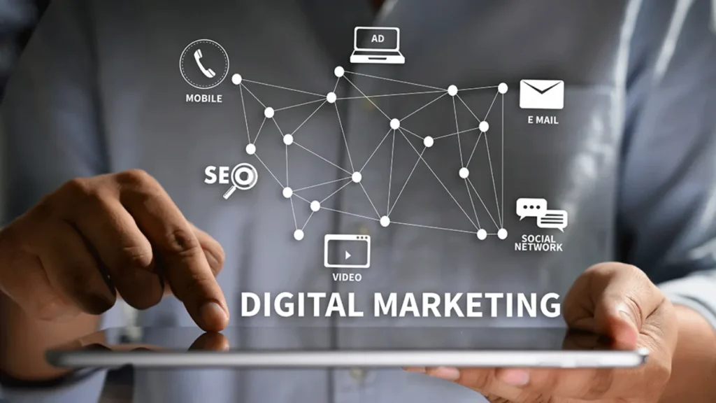 Person using a tablet with a digital marketing concept displayed. Icons for SEO, ads, email, social network, mobile, video connected by lines.